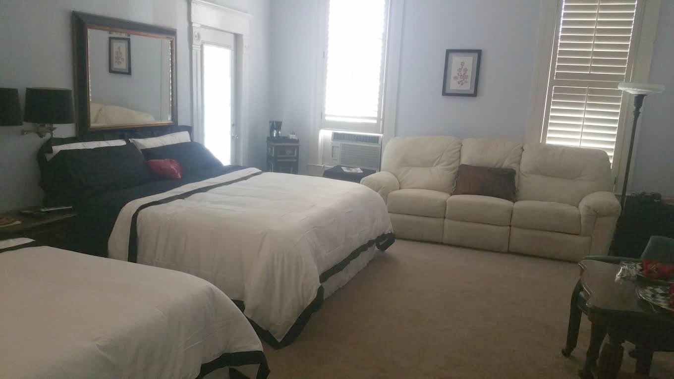 A bedroom with two beds and a couch